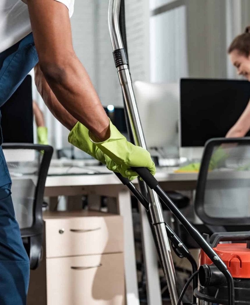 cropped-view-of-african-american-cleaner-moving-vacuum-cleaner-in-office.jpg